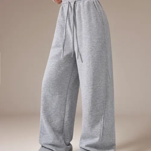 Women’s loose casual wide-leg sweatpants made from soft cotton blend fabric, featuring an elastic drawstring waistband and side pockets, suitable for everyday wear, sports, and home wear in autumn and winter.