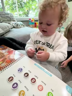 This Montessori busy book has her learning so much and having fun! #montessorilearning #busybook #toddlerlearning #finemotorskills #languagedevelopment 